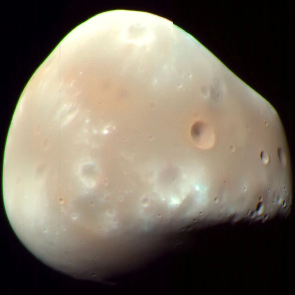 An archival orbital image shows Deimos, the second Martian moon MMX will investigate. The planned returned material comes from Phobos, not from a completed Deimos sampling campaign.