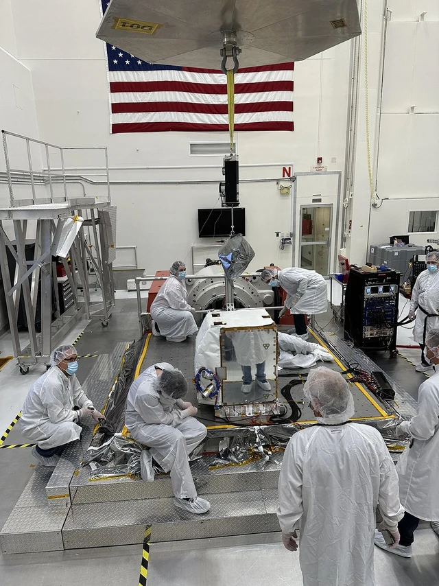 Cleanroom engineers prepare a real imaging spectrometer beside a vibration-test fixture